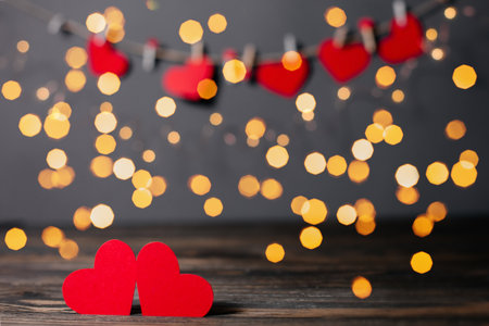 pair of red hearts on lights background, love and valentine concept on a wooden tableの写真素材