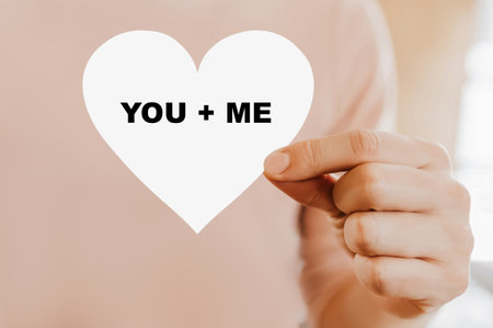 Man holding a love card in the shape of a heart with you and meの写真素材