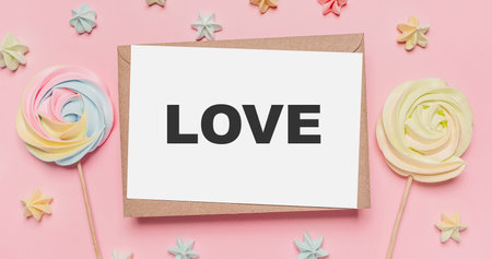 Gifts with note letter on isolated pink background with sweets, love and valentine conceptの写真素材