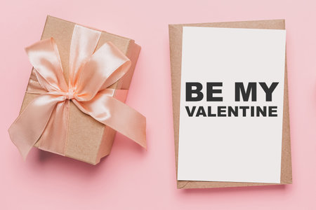 Gifts with note letter on isolated pink background, love and valentine concept with text be my Valentineの写真素材