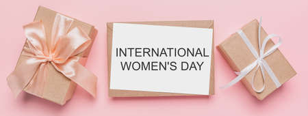 Gifts with note letter on isolated pink background, love and valentine concept with text International Womens Dayの写真素材