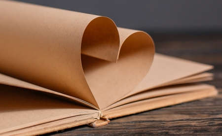 Heart made from book sheets, love and valentine concept on a wooden tableの写真素材