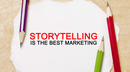 Text Storytelling is the best marketing on a white notepad with pencils on a wooden background. Business conceptの写真素材