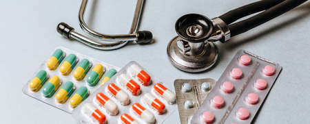 Medical concept flat lay with stethoscope and pills on a blue backgroundの写真素材