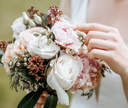 Girl bride holding a wedding bouquet of flowersの写真素材