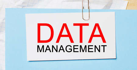 Text DATA MANAGEMENT on a white card on a blue background. Business conceptの写真素材