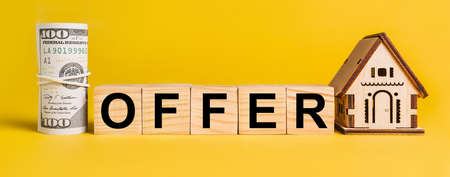 OFFER with house miniature model and money on a yellow background. The concept of business, finance, credit, tax , real estate, home, housingの写真素材