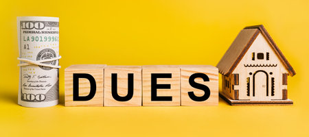 dues with house miniature model and money on a yellow background. The concept of business, finance, credit, tax , real estate, home, housingの写真素材