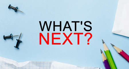 Text what is next on a white notepad with pencils on a blue background. Business conceptの写真素材
