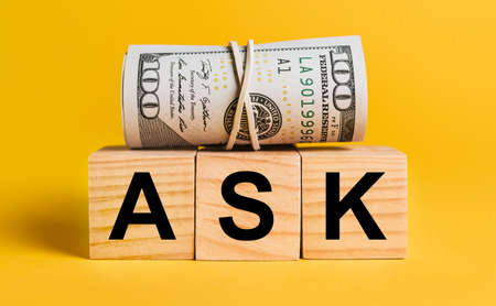 ASK with money on a yellow background. The concept of business, finance, credit, income, savings, investments, exchange, taxの写真素材