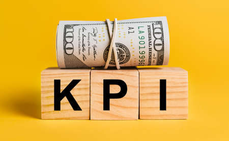 KPI with money on a yellow background. The concept of business, finance, credit, income, savings, investments, exchange, taxの写真素材