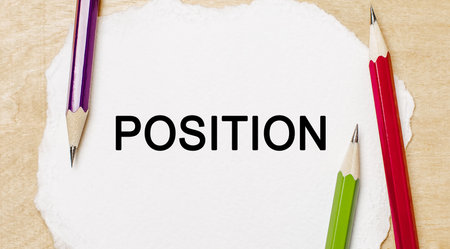 Text POSITION on a white notepad with pencils on a wooden background. Business conceptの写真素材
