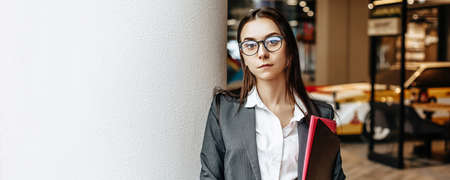 Businesswoman with documents for work. Student girl with folders with documentation. An officer will collect information.の写真素材