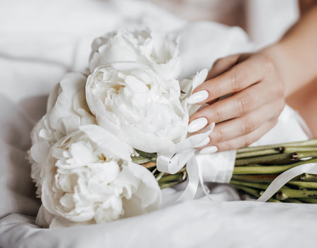 Girl bride holding a wedding bouquet of flowersの写真素材