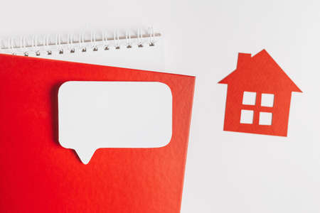 Sweet home. Estimating and paying house tax. Mock up with red house, notepad and sticker in copy space white backgroundの写真素材