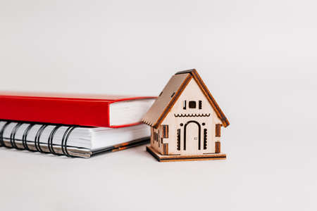 Sweet home. Estimating and paying house tax. Mock up with red house, notepad and sticker in copy space white backgroundの写真素材