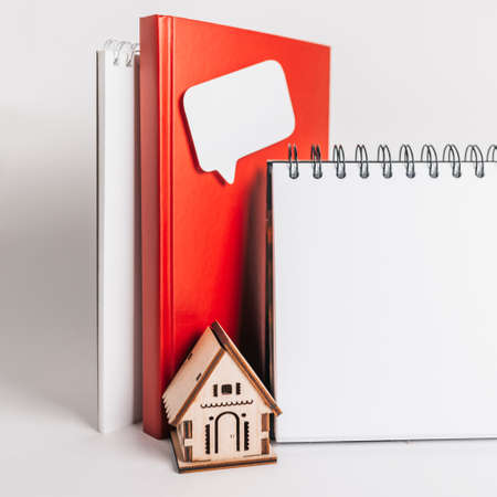 Sweet home. Estimating and paying house tax. Mock up with red house, notepad and sticker in copy space white backgroundの写真素材