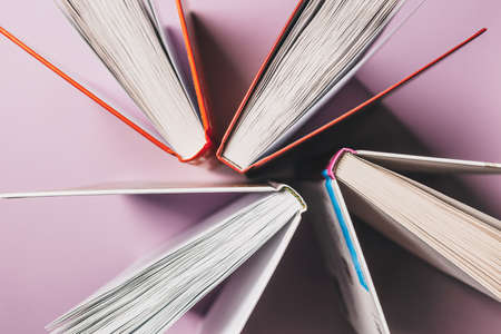 Open books on a pink background. Mock up with education and reading concept. Literature for learning, development and joyの写真素材
