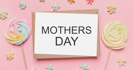 Gifts with note letter on isolated pink background with sweets, love and valentine concept with text mothers Dayの写真素材