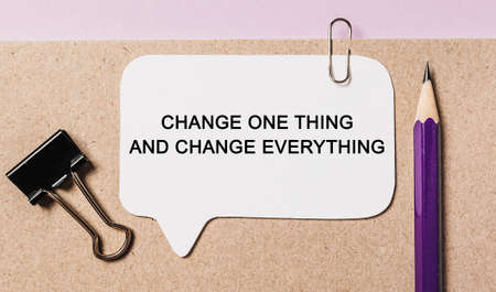 Text Change one thing and change everything on a white sticker with office stationery background. Flat lay on business, finance and development conceptの写真素材