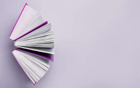 Open books on a purple background. Mock up with education and reading concept. Literature for learning, development and joyの写真素材