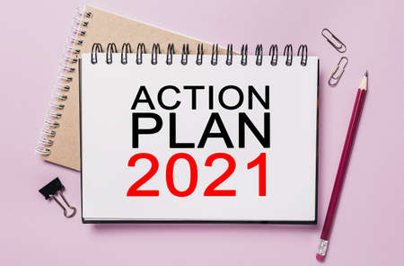 Text ACTION PLAN 2021 on a white sticker with office stationery background. Flat lay on business, finance and development conceptの写真素材
