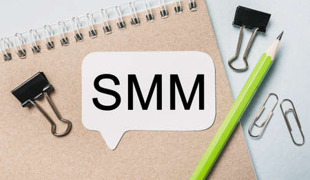 Text smm on a white sticker with office stationery background. Flat lay on business, finance and development conceptの写真素材