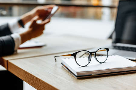 Glasses at the workplace in the office near the laptop and notepad. Business hoursの写真素材