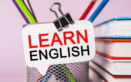 Text Learn ENGLISH on a white sticker with office stationery background. Flat lay on business, finance and development conceptの写真素材