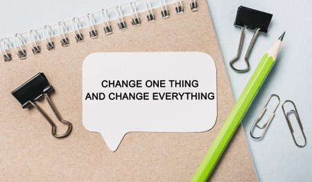 Text Change one thing and change everything on a white sticker with office stationery background. Flat lay on business, finance and development conceptの写真素材