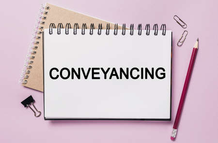 Text Conveyancing on a white sticker with office stationery background. Flat lay on business, finance and development conceptの写真素材