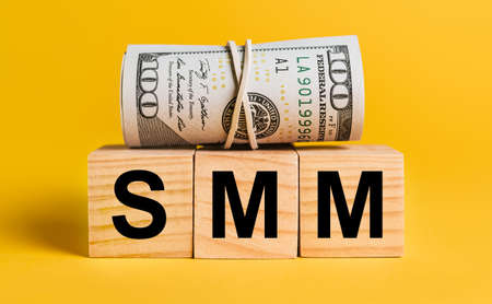 SMM with money on a yellow background. The concept of business, finance, credit, income, savings, investments, exchange, taxの写真素材
