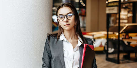 Businesswoman with documents for work. Student girl with folders with documentation. An officer will collect information.の写真素材