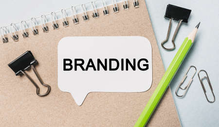 Text branding on a white sticker with office stationery background. Flat lay on business, finance and development conceptの写真素材