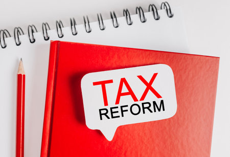 Text tax reform on a white sticker with office stationery background. Flat lay on business, finance and development conceptの写真素材