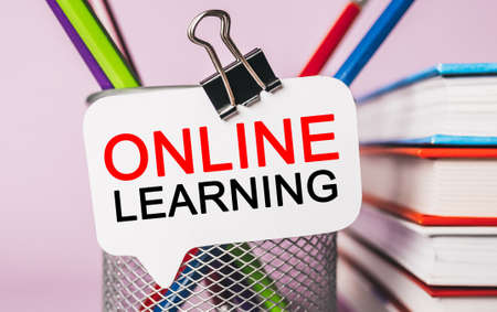 Text online learning on a white sticker with office stationery background. Flat lay on business, finance and development conceptの写真素材