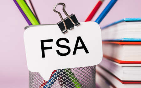 Text FSA on a white sticker with office stationery background. Flat lay on business, finance and development conceptの写真素材