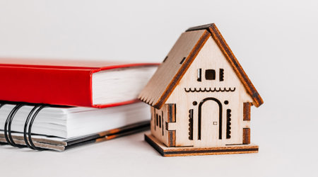 Sweet home. Estimating and paying house tax. Mock up with red house, notepad and sticker in copy space white backgroundの写真素材