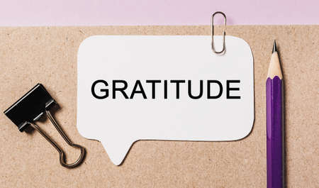 Text Gratitude on a white sticker with office stationery background. Flat lay on business, finance and development conceptの写真素材