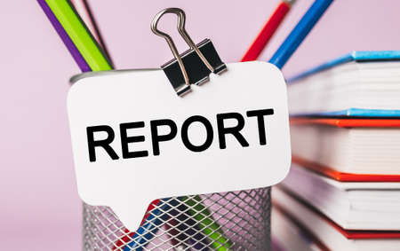 Text REPORT on a white sticker with office stationery background. Flat lay on business, finance and development conceptの写真素材