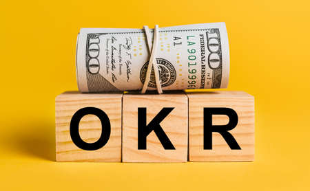 OKR with money on a yellow background. The concept of business, finance, credit, income, savings, investments, exchange, taxの写真素材