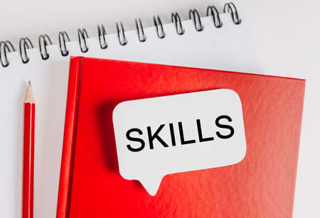Text SKILLS on a white sticker with office stationery background. Flat lay on business, finance and development conceptの写真素材