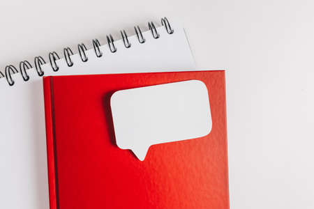 Red notepad and white sticker on the desk. Mock up in copy space office background. It is important not to forget the noteの写真素材