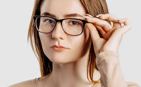 Beautiful young business woman wearing glasses isolated on gray background. Achieving career wealth business concept.の写真素材