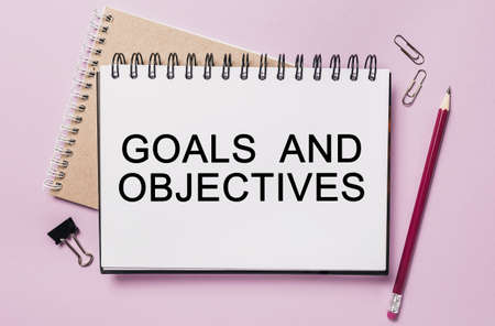 Text Goals and Objectives on a white sticker with office stationery background. Flat lay on business, finance and development conceptの写真素材