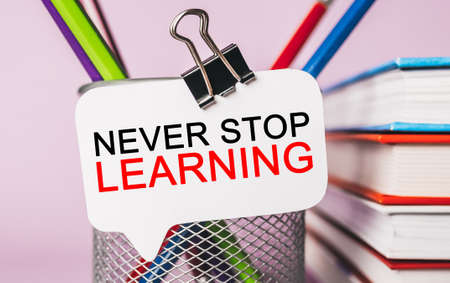 Text Never Stop Learning on a white sticker with office stationery background. Flat lay on business, finance and development conceptの写真素材