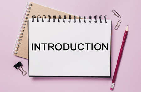 Text Introduction on a white sticker with office stationery background. Flat lay on business, finance and development conceptの写真素材