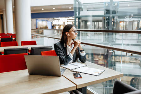 Girl works on a laptop in the workplace. Successful business woman creates a startup and makes decisions.の写真素材