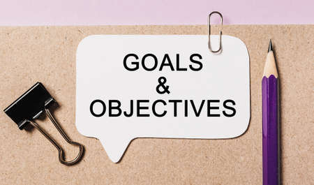 Text Goals and Objectives on a white sticker with office stationery background. Flat lay on business, finance and development conceptの写真素材