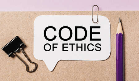 Text Code of Ethics on a white sticker with office stationery background. Flat lay on business, finance and development conceptの写真素材